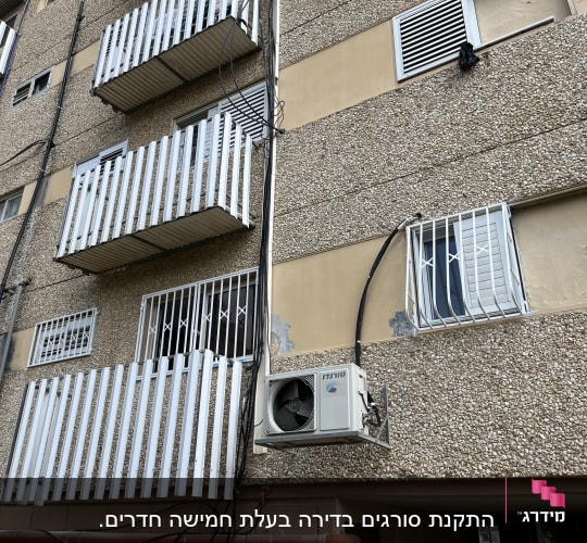מרפסות עם מסגרות מתכת לבנות על קיר בניין